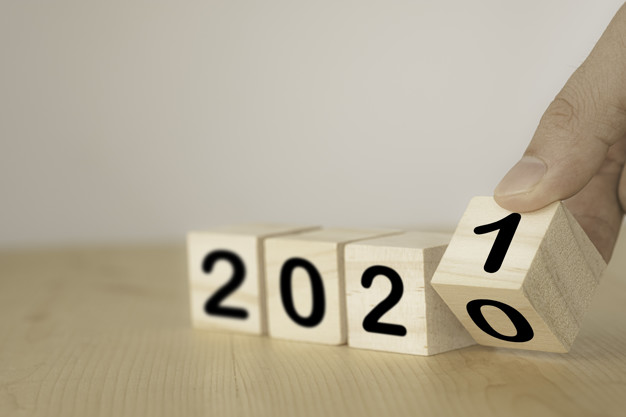 Hand flipping wooden blocks for change year 2020 to 2021 . New